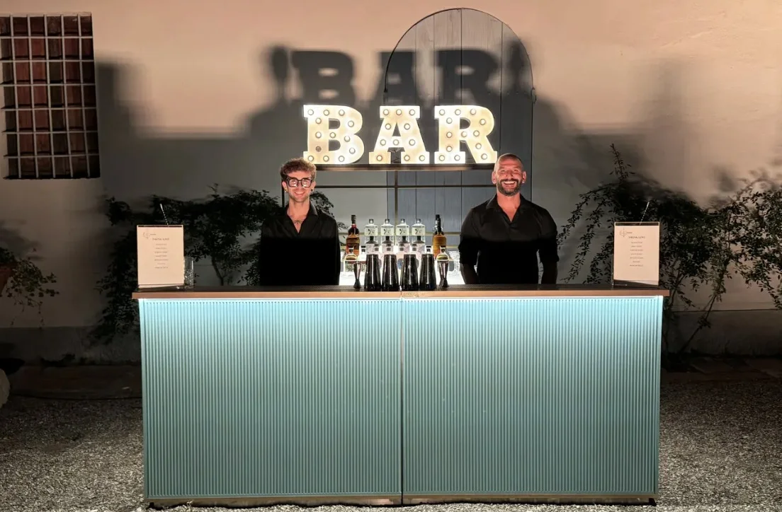 Open bar Marinelli con insegna BAR luminosa e due bartender